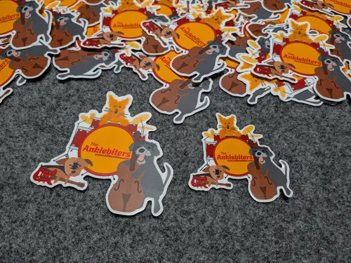 A photo of several The Anklebiters stickers scattered on a table.